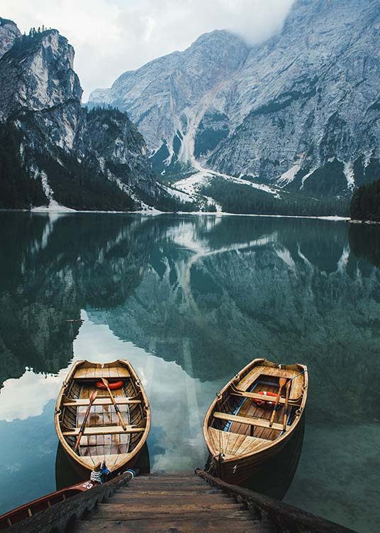  – Fotografía de dos botes en una lago tranquilo con montañas bajo la niebla de fondo