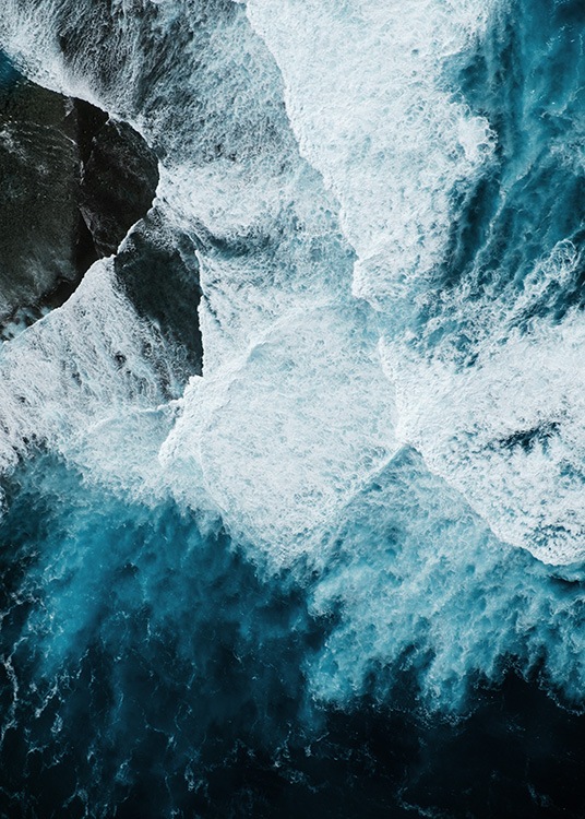 –Toma aérea de olas rompiendo contra las rocas. 