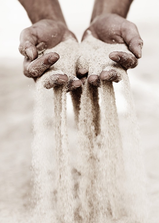  – Fotografía de dos manos llenas de arena que se cuela entre los dedos