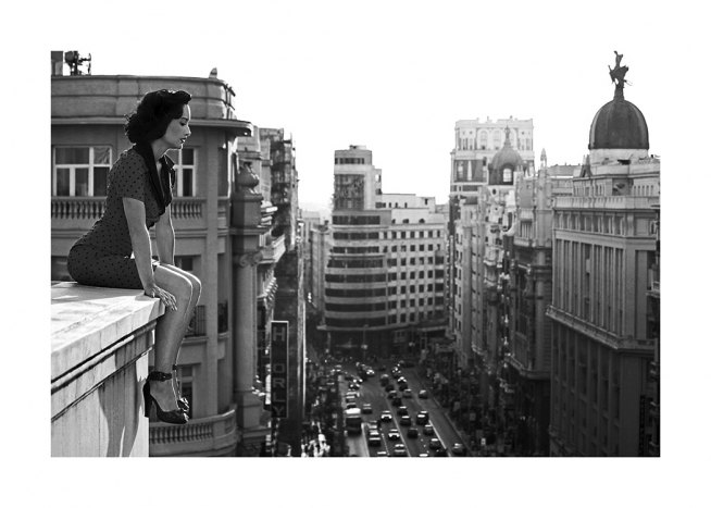 Fotografía en blanco y negro de una mujer contemplando la ciudad desde una azotea