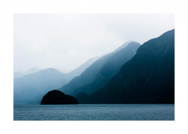  - Fotografía de montañas y mar azul con neblina. 