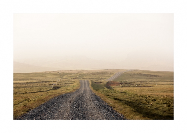  - Fotografía de un sendero de grava negra en un paisaje verde y dorado cubierto por la niebla en Islandia