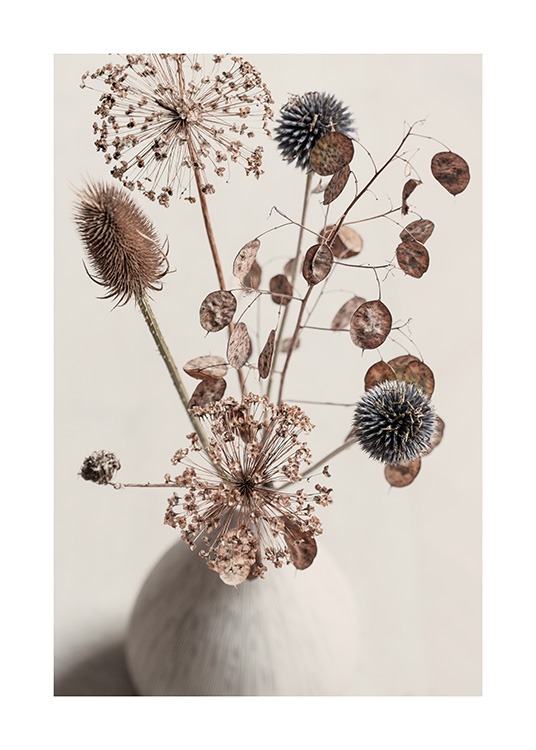  - Fotografía de un florero beis con un ramo de flores secas en tonos de beis y marrón sobre un fondo beis.