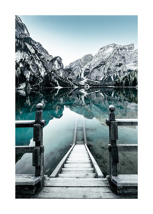  - Fotografía de una escalera que conduce al lago Braies en Italia, con montañas cubiertas de nieve al fondo. 