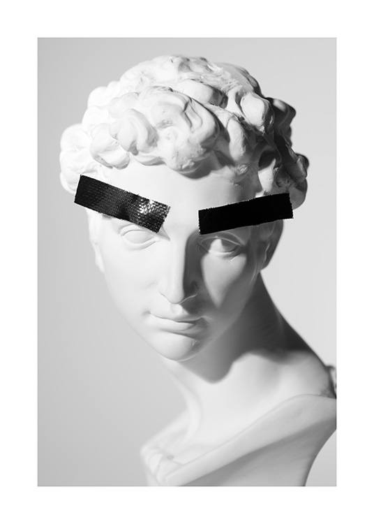  - Fotografía de una estatua de mármol blanca con dos cintas adhesivas negras en las cejas. 