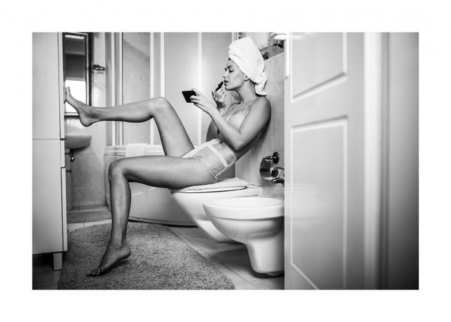  – Fotografía en blanco y negro de una mujer en ropa interior que se pinta los labios sentada en un cuarto de baño con los pies apoyados sobre la pared.