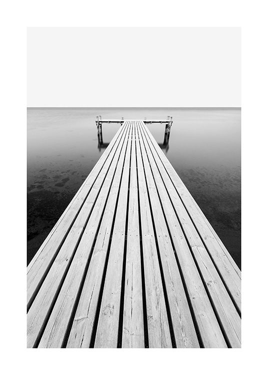  – Fotografía en blanco y negro de un muelle que conduce al mar.