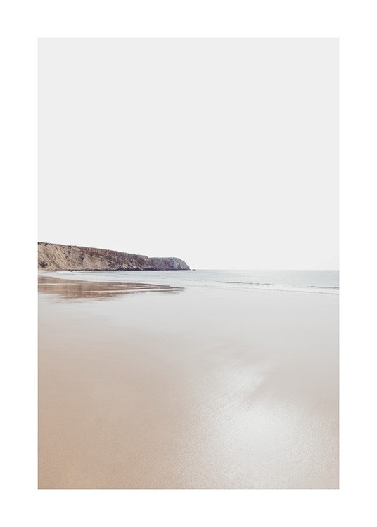  – Fotografía de una playa con un mar en calma y un extenso acantilado a la distancia.