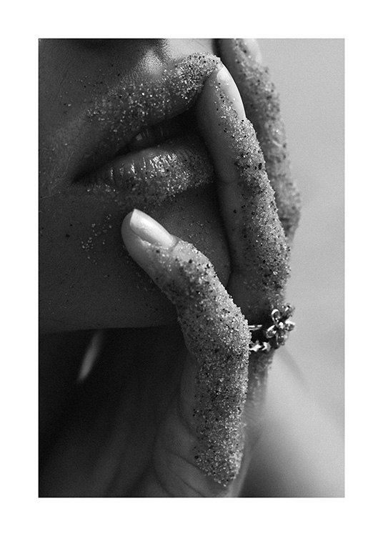  – Fotografía en blanco y negro de una mujer con los dedos llenos de arena cubriéndose parte de la boca.