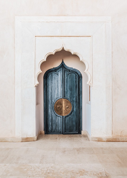  - Fotografía de una puerta azul con mango dorado y un arco marroquí de silueta ondulante al frente. 