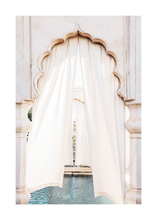  - Fotografía de una cortina blanca en una puerta con arco marroquí frente a una piscina.