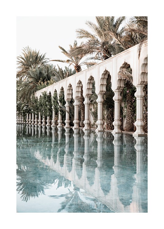  - Fotografía de columnas y arcos marroquíes blancos en una piscina con palmeras en el fondo.