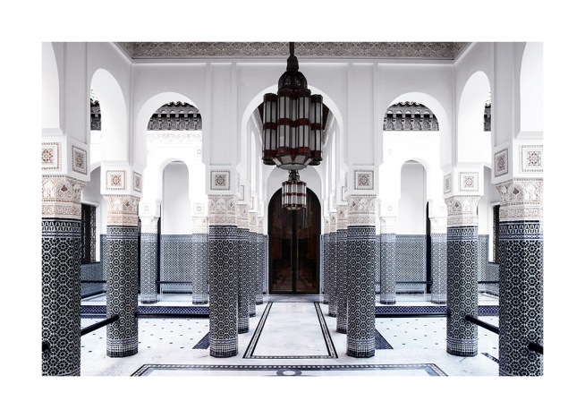  - Fotografía de una estancia grande con columnas blancas decoradas en azul y una puerta negra.