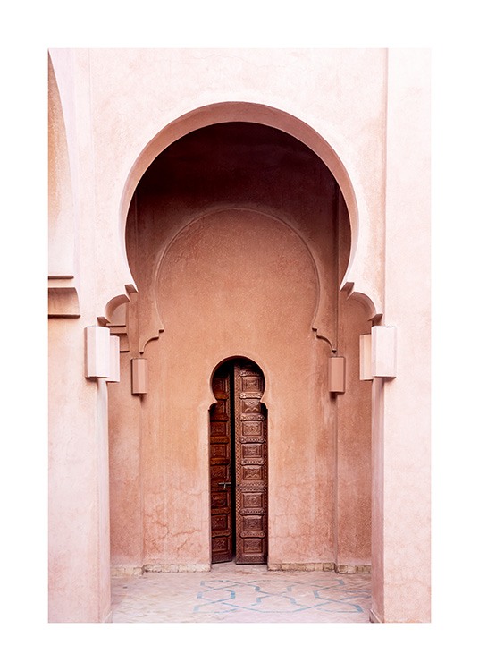  - Fotografía de un edificio rosa con arcos y una puerta marrón y angosta.