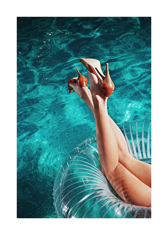  – Fotografía de una mujer con tacones rojos con un flotador de aro en la piscina