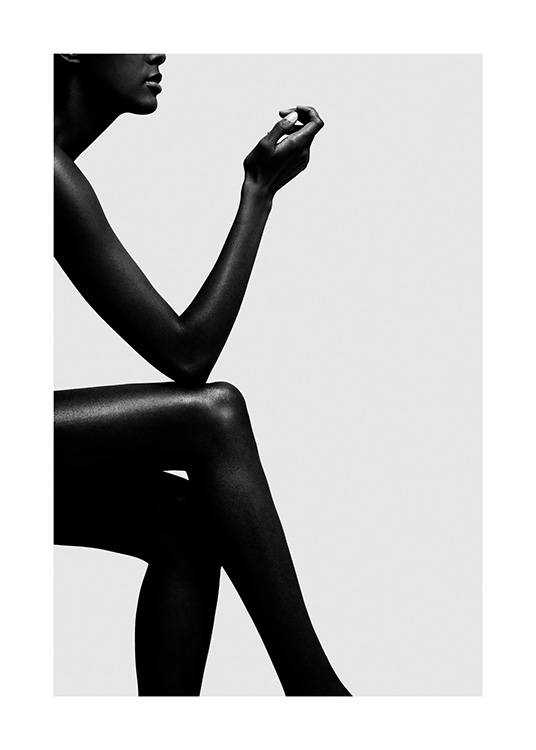  – Fotografía en blanco y negro del perfil de una mujer sentada con las piernas cruzadas y el codo apoyado sobre la rodilla, fondo gris.