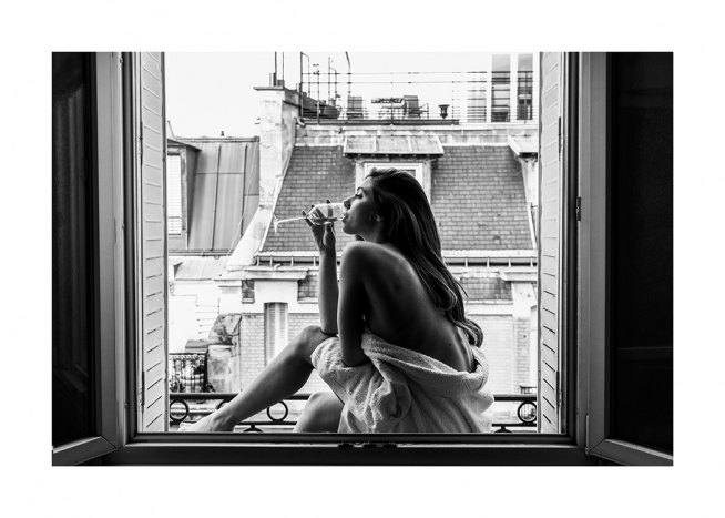  – Fotografía en blanco y negro con la imagen de una mujer sentada en el marco de una ventana tomando un vaso de vino.