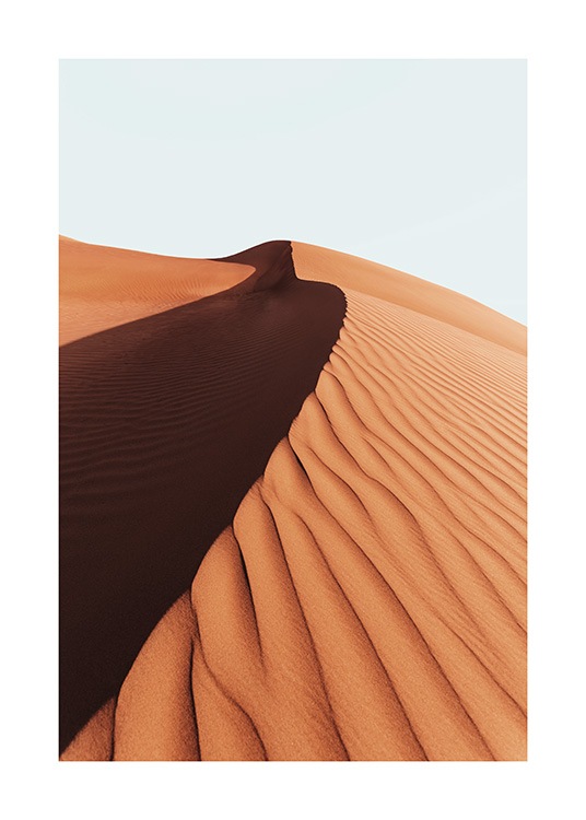  – Fotografía de la cresta de una duna grande en un desierto y un cielo azul claro detrás.