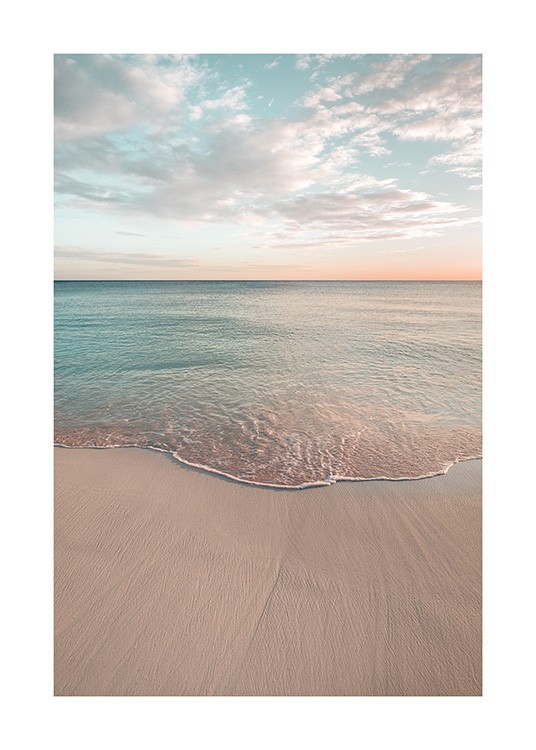  – Fotografía de una playa de mar calmo bajo un cielo azul y anaranjado con nubes blancas.