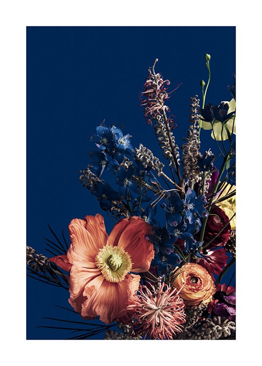  – Fotografía de un florero con un ramo de flores rojas y azules, fondo azul oscuro.
