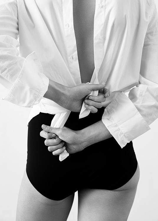  – Fotografía en blanco y negro de la espalda de una mujer que lleva una camisa blanca y bragas negras de cintura alta.