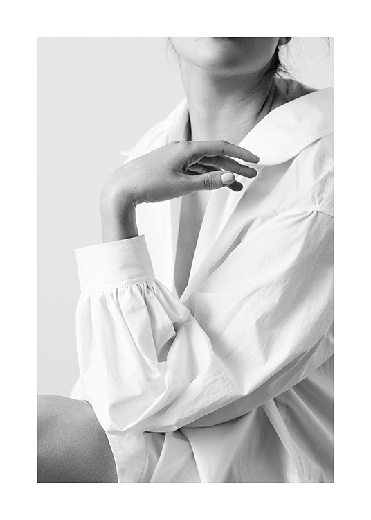  – Fotografía en blanco y negro de una mujer con camisa blanca con una mano en una posición elegante y sensual delante de su pecho.