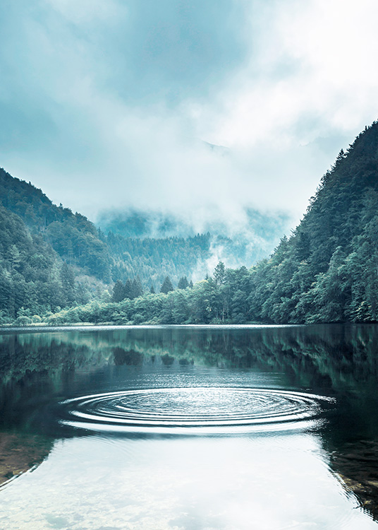  – Fotografía de un lago con ondas en el agua y un bosque bajo la niebla de fondo