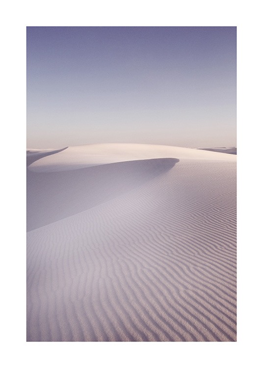  – Fotografía de unas dunas estriadas por el viento bajo un cielo azul