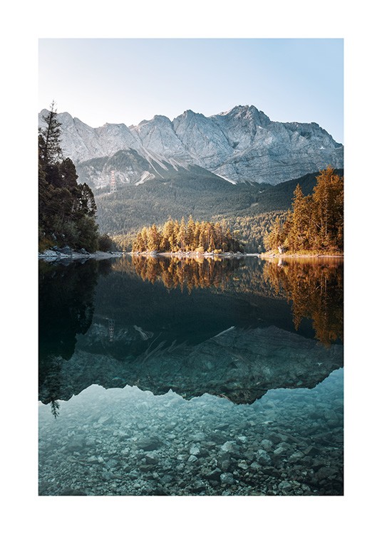  – Fotografía con unpaisaje montañoso y árboles de hojas anaranjadas reflejados en el agua de un lago
