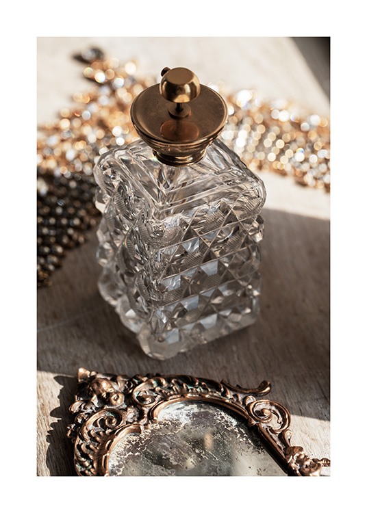  – Fotografía de un botella de vidrio antigua con tapa dorada y un espejo de bronce