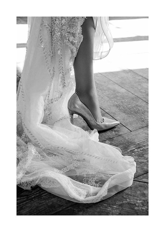  – Fotografía en blanco y negro de una mujer con tacones y un vestido de tul blanco con detalles bordados 