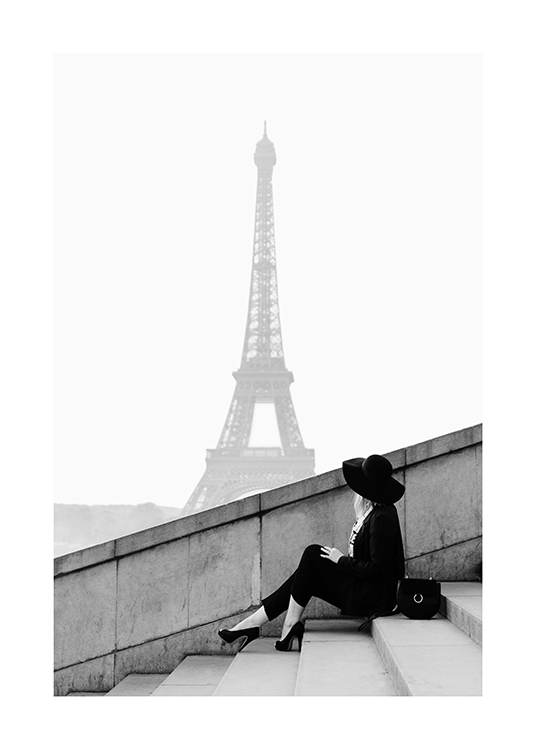  – Fotografía en blanco y negro de una mujer en unas escalinatas con la Torre Eiffel de fondo