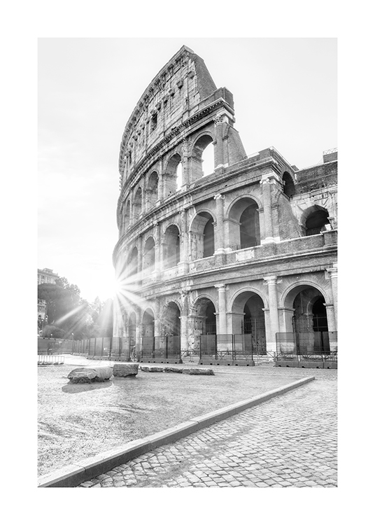  – Fotografía en blanco y negro del Coliseo de Roma con rayos de sol colándose de fondo