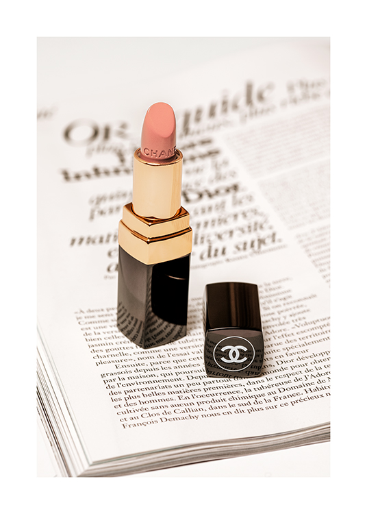  – Fotografía de una barra de labios color rosa de Chanel sobre la hoja de una libro abierto