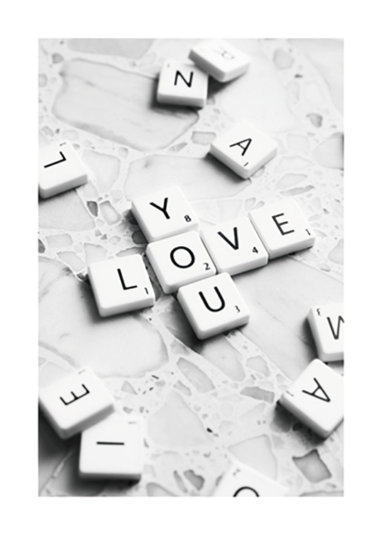  – Fotografía de unas fichas de Palabras cruzadas que forman la frase Love You sobre una superficie de mármol