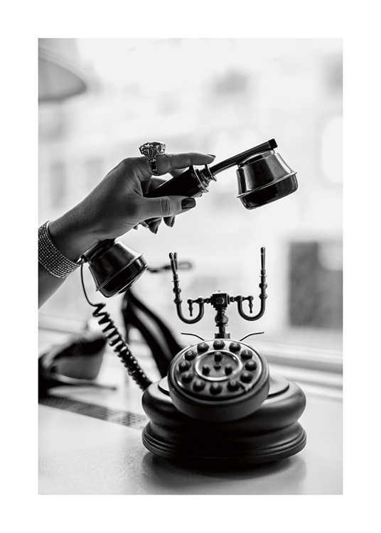  – Fotografía en blanco y negro de una mujer con un teléfono antiguo y un anillo grande