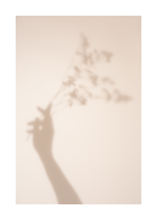  – Fotografía de la sombra de una mano con flores sobre un fondo beis claro