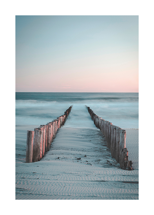  – Fotografía de una playa con dos hileras de troncos de madera que conducen a un mar con bruma