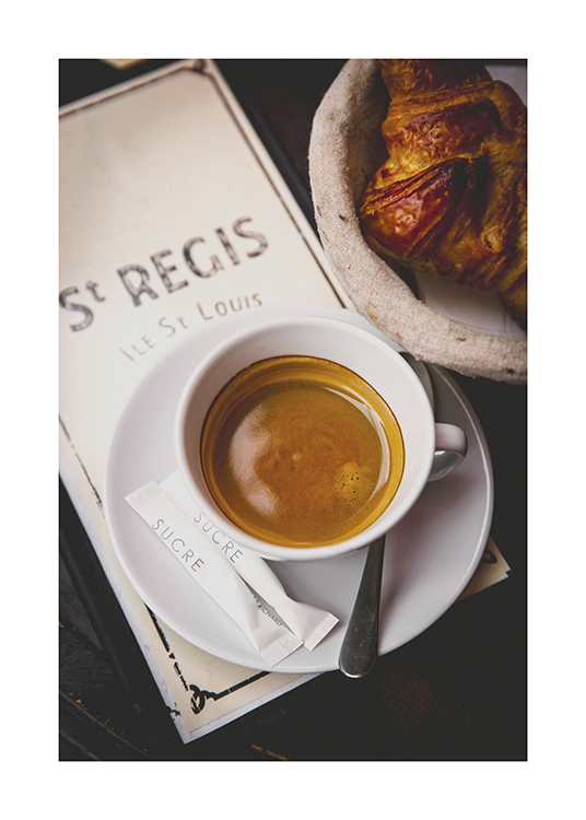  – Fotografía de un cruasán y una taza de café en la mesa de un café en París