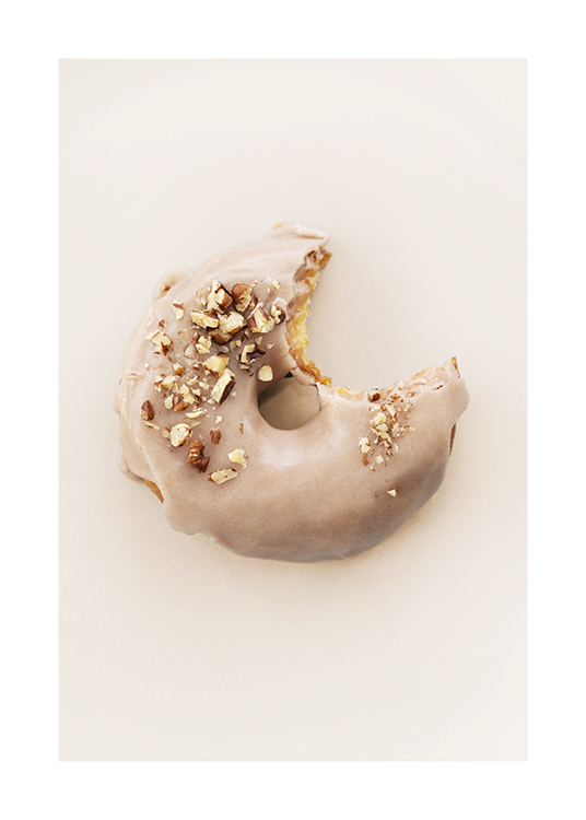  – Fotografía de una rosquilla con glaseado beis y cobertura de nueces