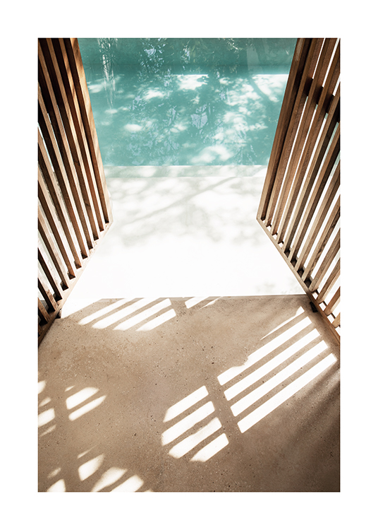  – Fotografía de una puerta de madera abierta y una piscina de fondo