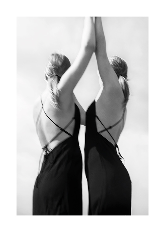  – Fotografía en blanco y negro de dos mujeres con los brazos levantados