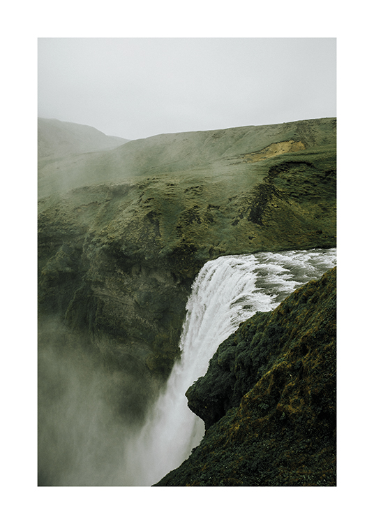  – Fotografía de un paisaje de vegetación espesa con una cascada en el centro de la imagen y niebla