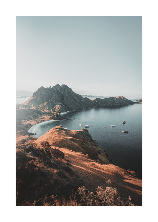  – Fotografía de un paisaje con embarcaciones en el mar y una costa con acantilados altos en la isla de Padar en Indonesia