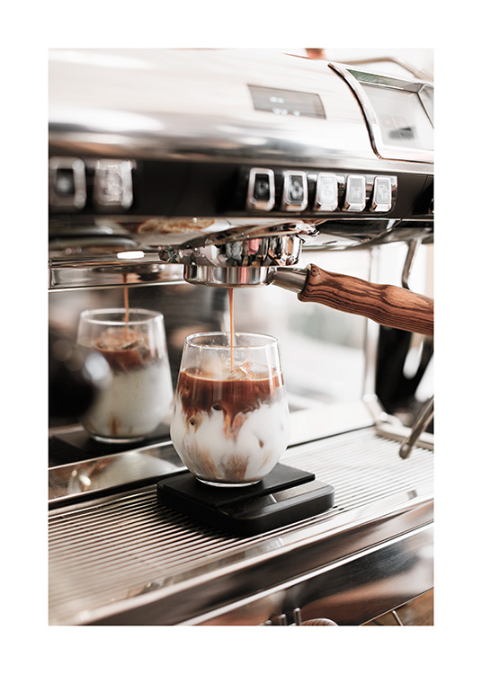  – Fotografía de un vaso de vidrio con café con hielo preparándose en una máquina de café