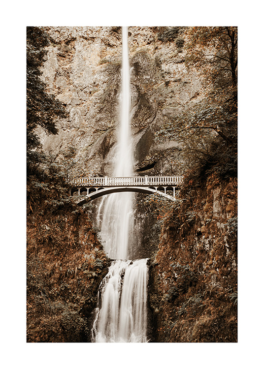  – Fotografía de un paisaje con una cascada en la montañas y un puente en el centro de la imagen