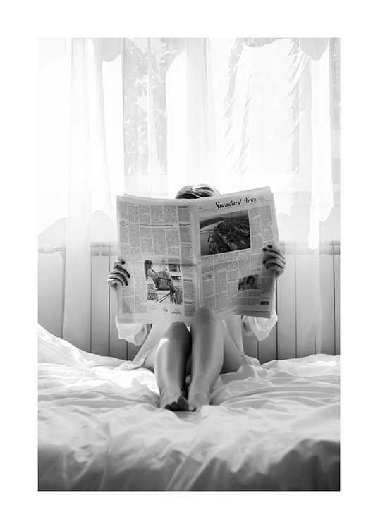  – Fotografía en blanco y negro de una mujer leyendo el periódico en la cama