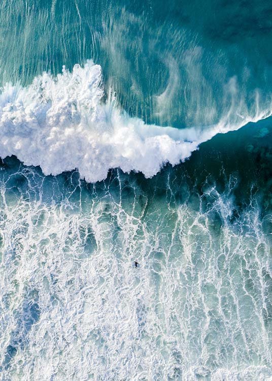  – Fotografía tomada desde el aire; olas en el mar y una persona haciendo surf en el medio de la toma