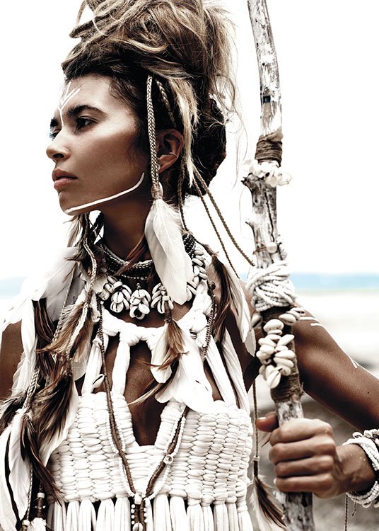  – Fotografía de una mujer con un top blanco, joyería y plumas