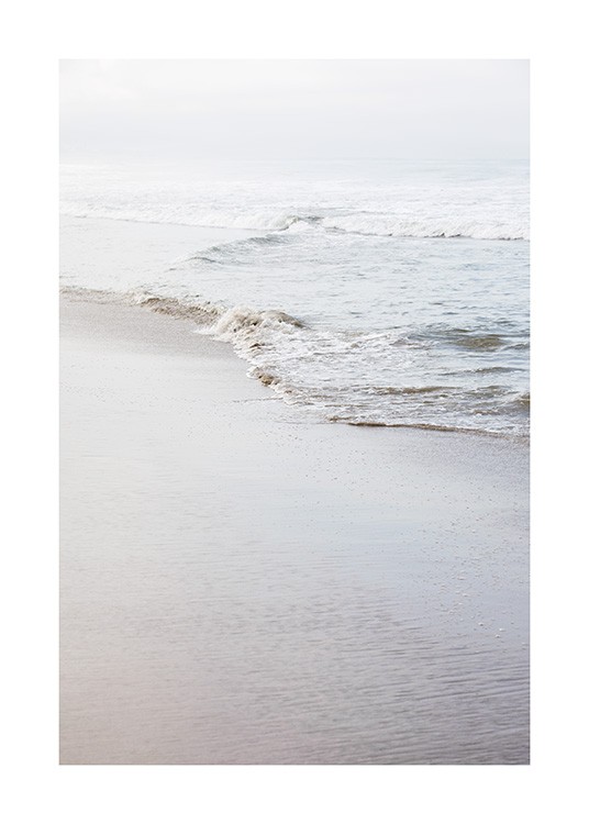  - Fotografía de una playa en una costa calma bañada por una suave olas.
